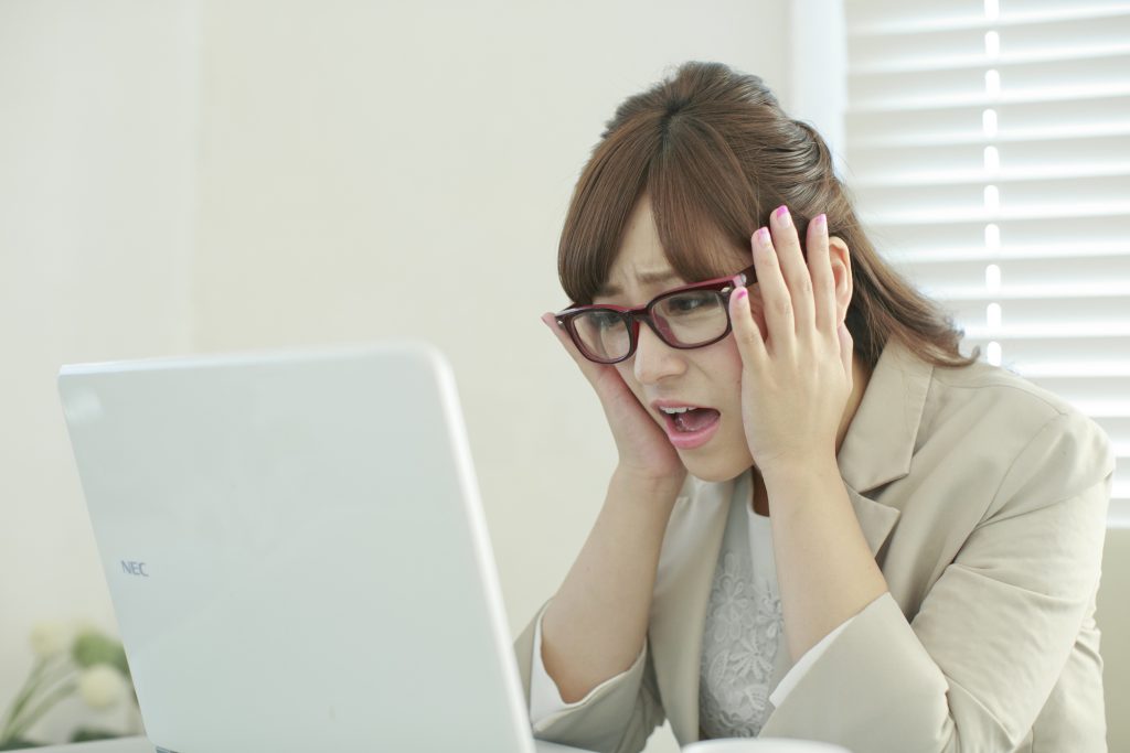 パソコンの前で困った表情の女性